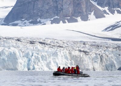 Zodiac cruising in front of iceberg