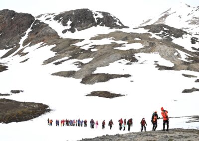 People hiking in the snowy landscape of Svalbard