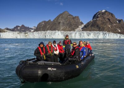 Guests in zodiac in front of big glacier